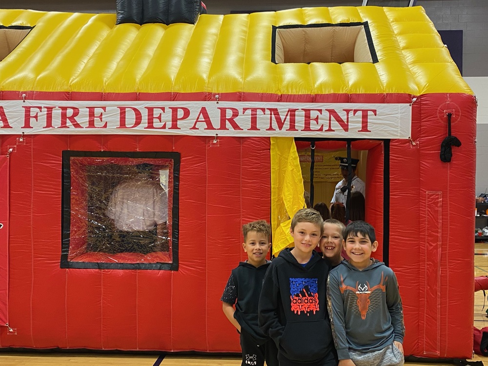 Students practicing fire safety with the bounce house