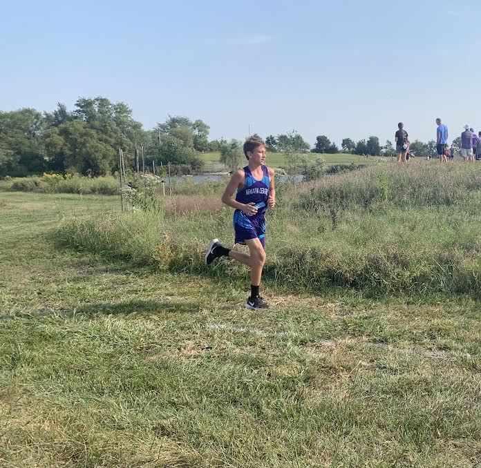 Brady Koch runs in front of the other people running to finish in first place.